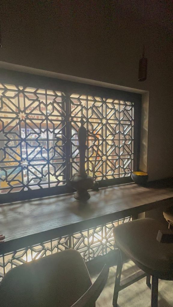 Mashrabiya screens playing with light and shadow in traditional design.
