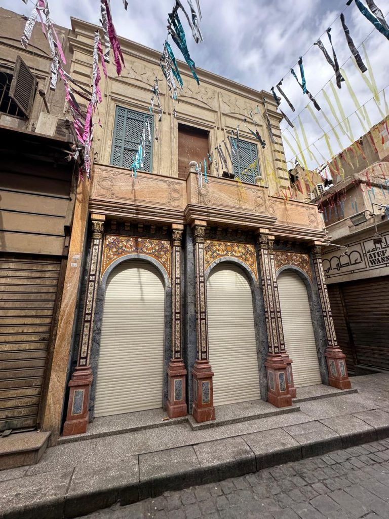 Historic Cairo street with wooden mashrabiya and traditional banners, embodying urban heritage