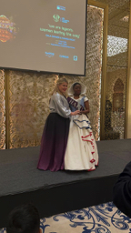 Warm stage moment with Claire and honoree from Haiti during award presentation